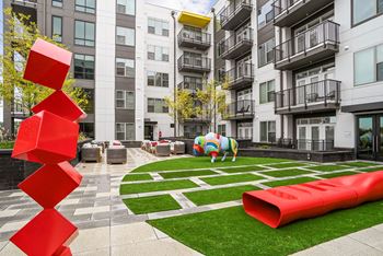 An apartment courtyard with a large red sculpture in front of an apartment building